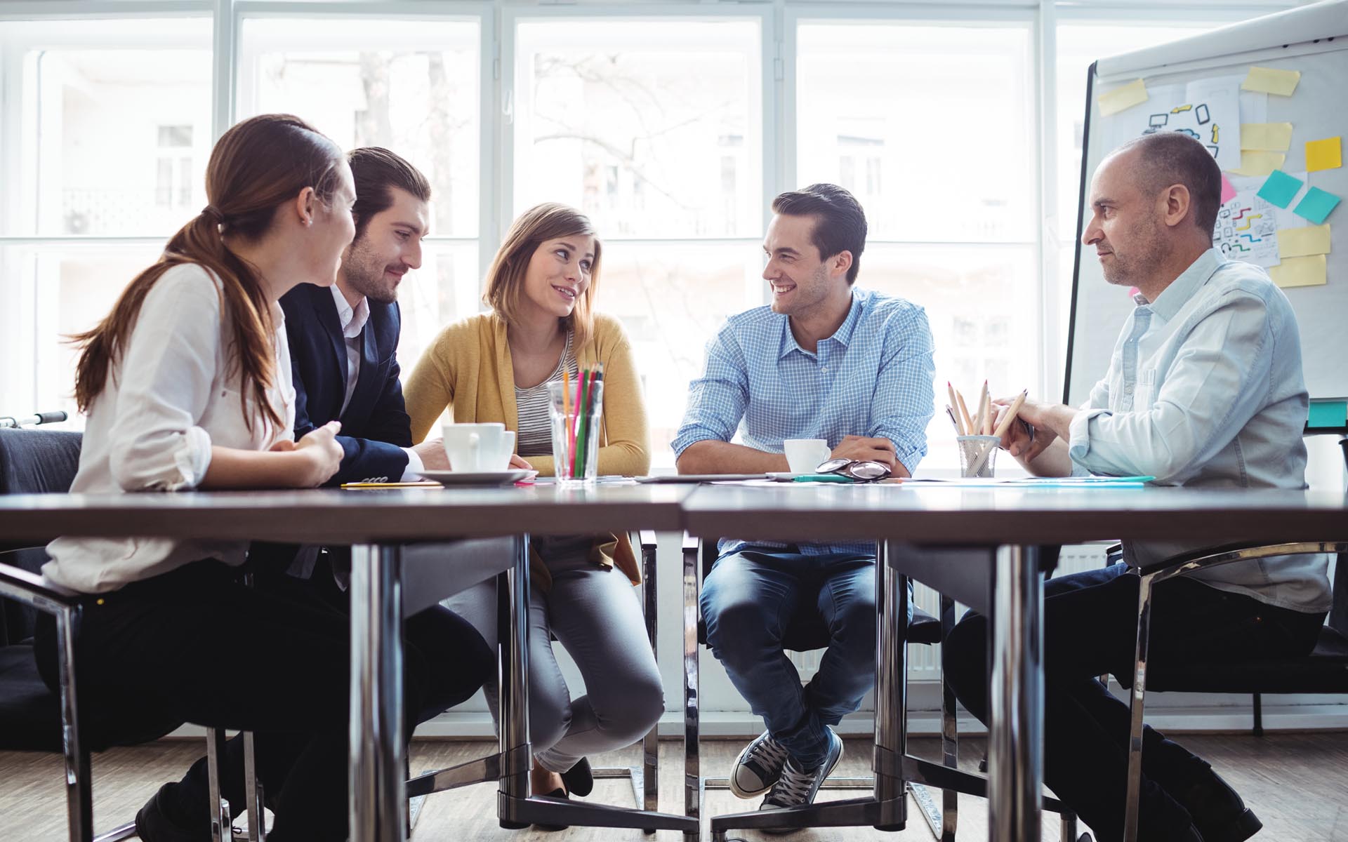 Homepage - Employees Sitting Around in a Meeting